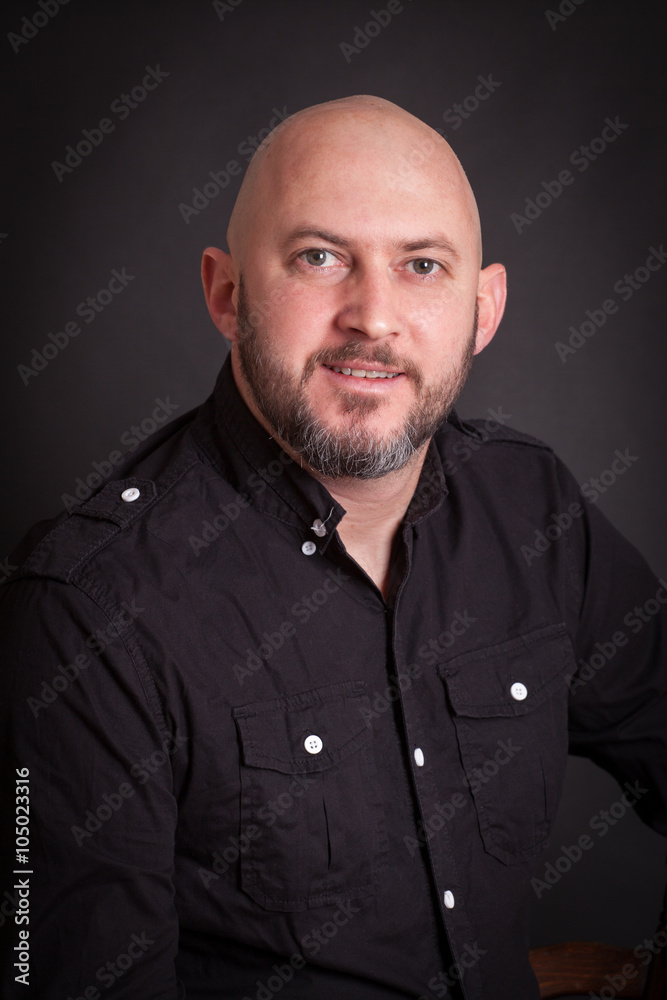 studio portrait of smiling bold man with beard