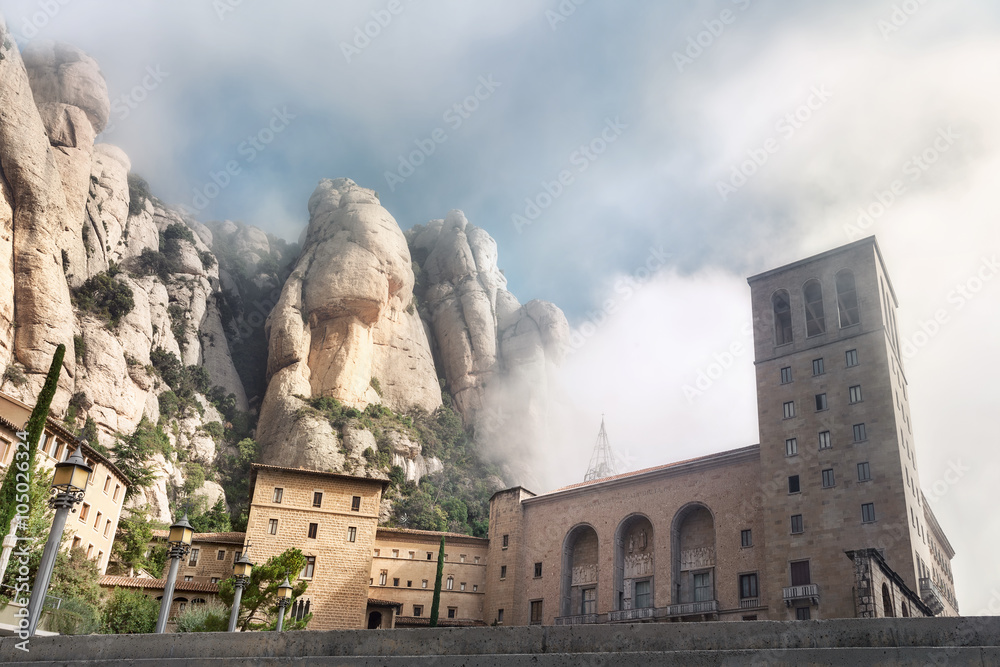 Montserrat monastery against mountains background in foggy morn