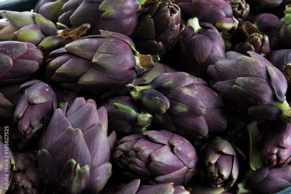 Insieme di carciofi violetti freschi raccolti e posati su un tavolo Insieme di carciofi violetti freschi raccolti e posati su un tavolo