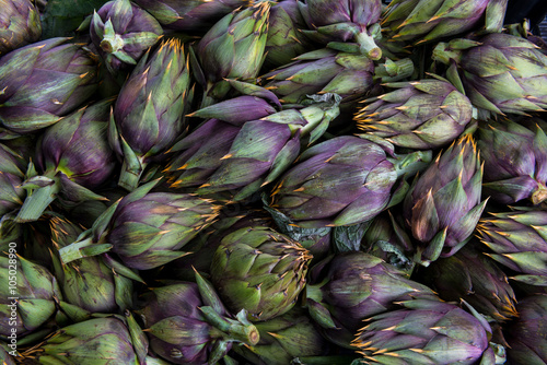 Insieme di carciofi spinosi violetti  freschi raccolti e posati su un tavolo photo