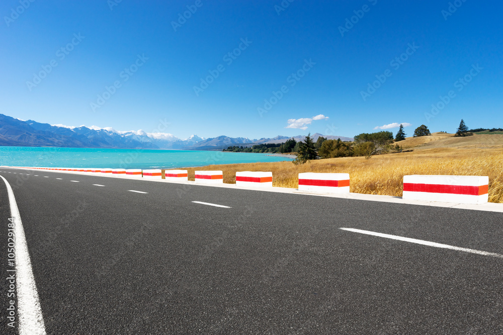 Fototapeta premium asphalt road near lake in summer day in New Zealand