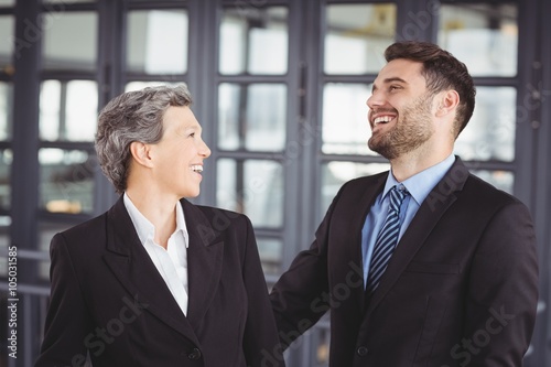 Business people laughing while standing in office