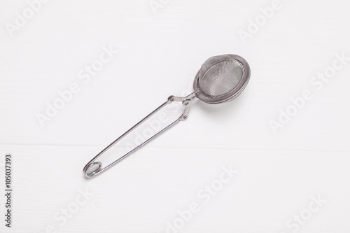 Tea in a tea strainer ball on wooden background
