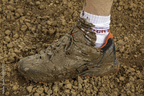 Dirty shoe - sneakers on mud photo