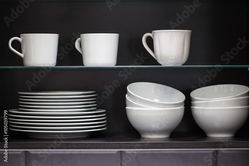 Plates with cups in the cupboard