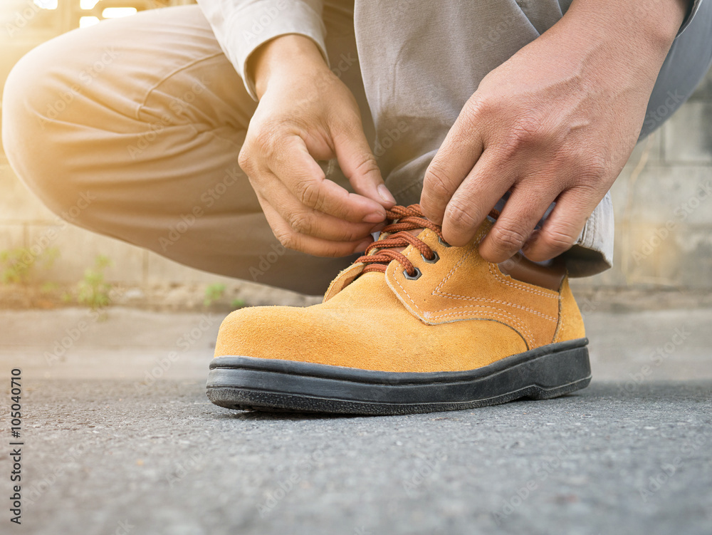  The man wears safety shoes on street