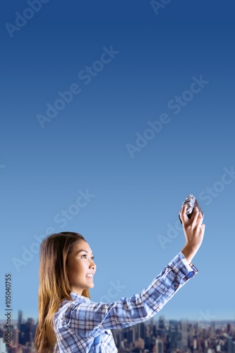 Composite image of smiling asian woman taking picture