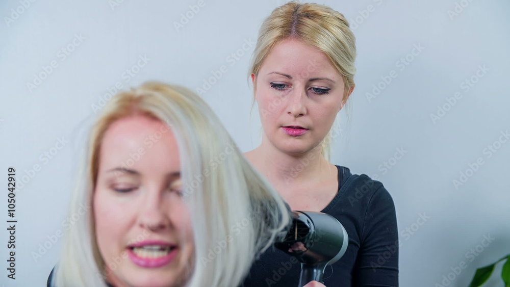 Young hair stylist making a hair style Young hair stylist making a hair style