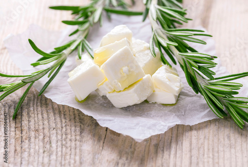 feta cheese portion on the wooden background with rosemary