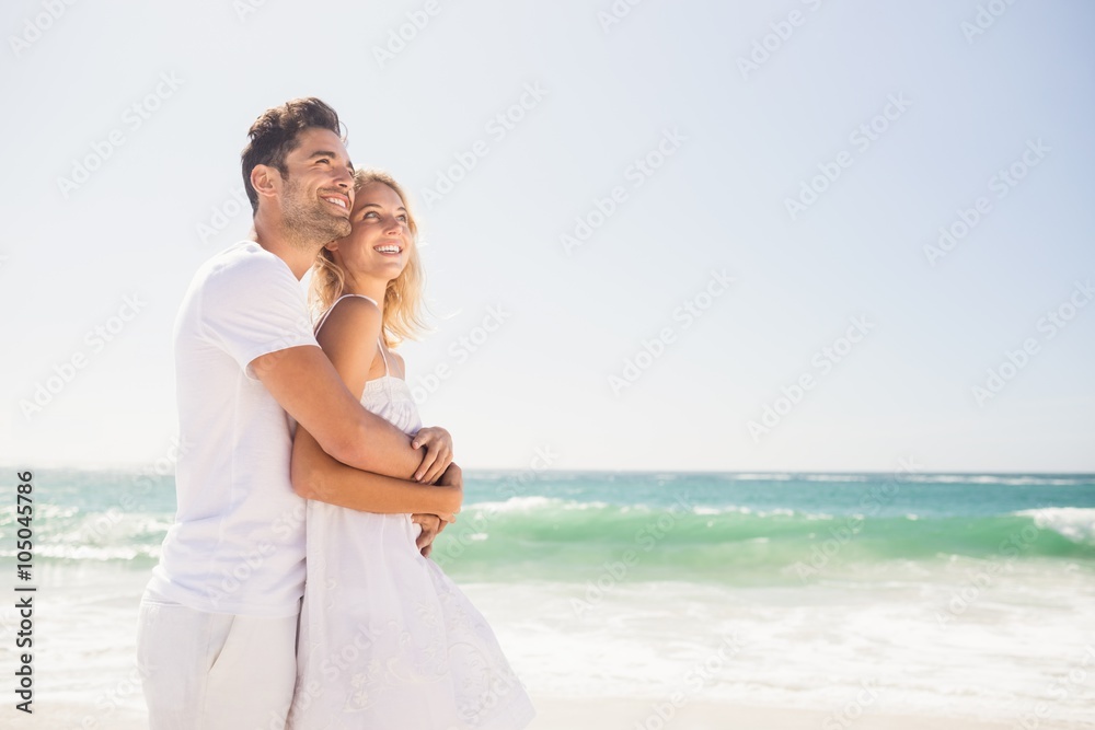 Smiling young couple hugging on the beach Smiling young couple hugging on the beach