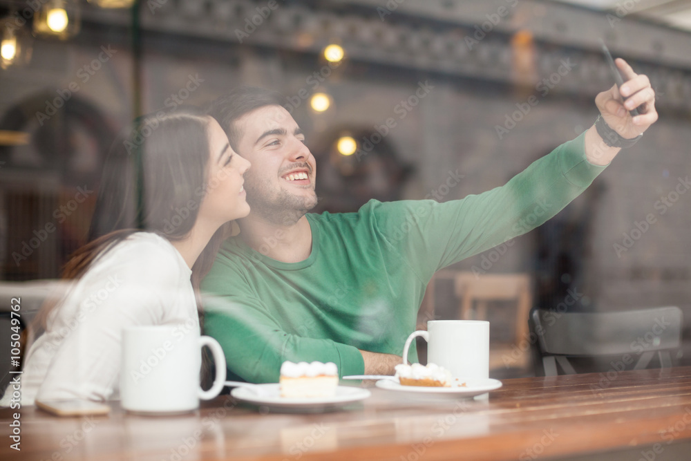 Cute couple taking selfie in a coffee shop Cute couple taking selfie in a coffee shop
