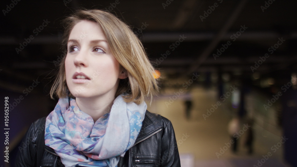 Young woman on an escalator checking her phone as it ascends Young woman on an escalator checking her phone as it ascends