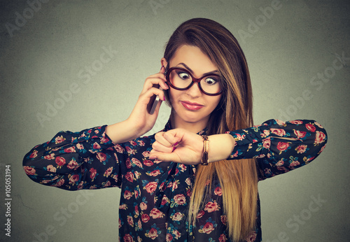 Valokuva Stressed surprised business woman looking at wrist watch, running late for meeting