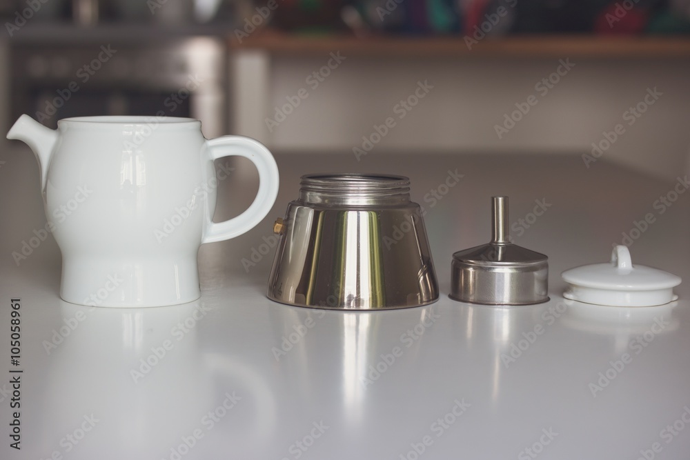Obraz premium Disassembled steam white ceramic with metal coffee maker on a white table