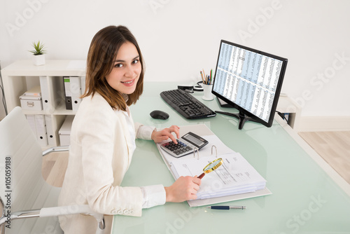 Businesswoman Checking Invoice With Magnifying Glass