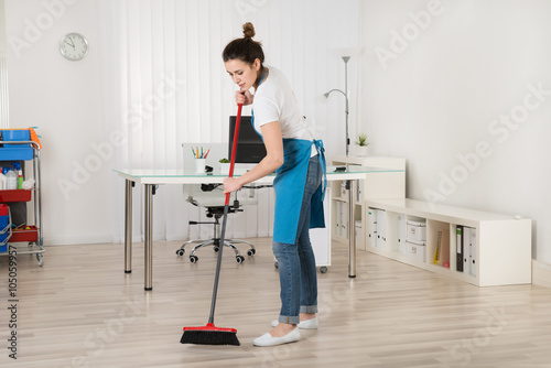 Female Janitor Sweeping Floor With Broom