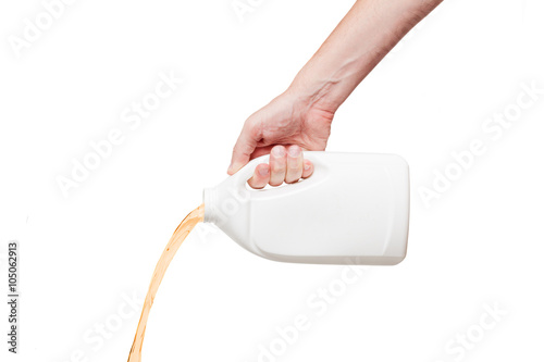 Engine oil pouring from a canister in hand isolated on white bac