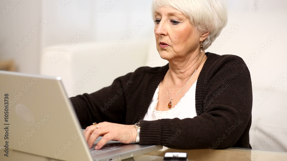 Senior woman using laptop and cell phone Senior woman using laptop and cell phone