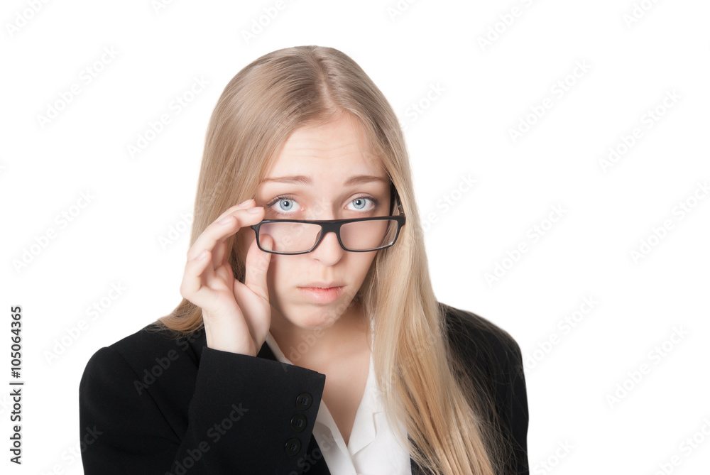 Beautiful puzzled business woman lifting her glasses in surprise