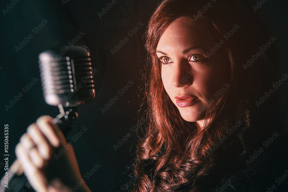 Pretty Woman with Vintage Microphone. Attractive female singing into a