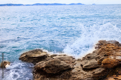 Water splashing. Crystal clear sea water beating against the roc