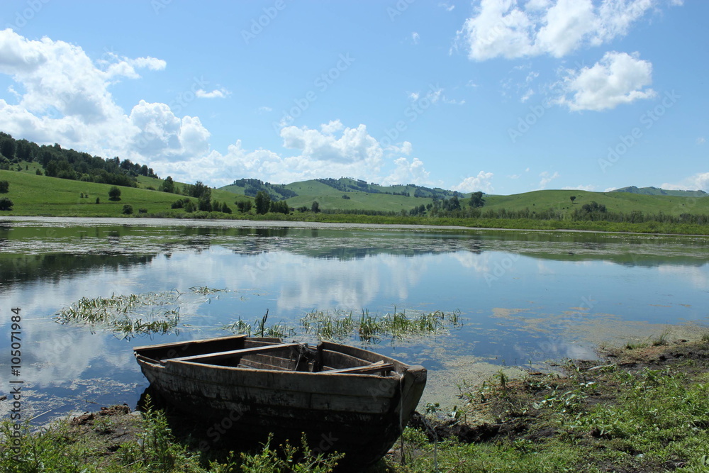 old wooden boat on the bank of the lake