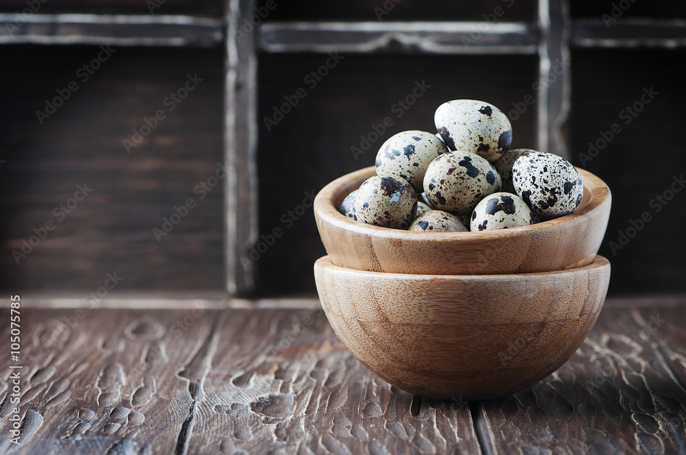 Uncooked quail eggs on the wooden table Uncooked quail eggs on the wooden table