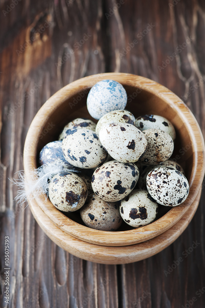 Uncooked quail eggs in the wooden bowl Uncooked quail eggs in the wooden bowl