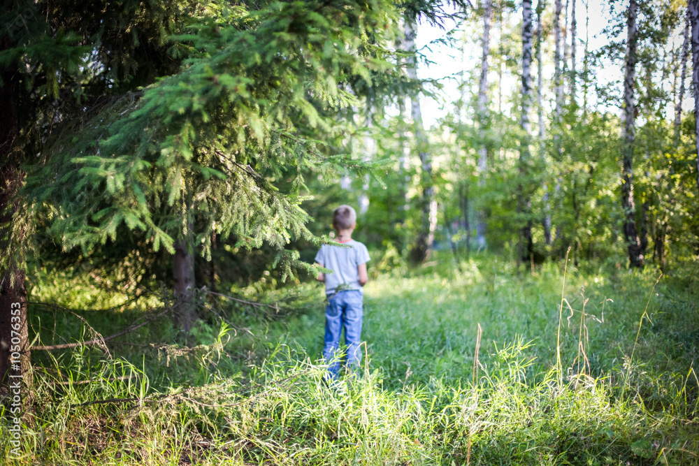 Young guy standing in a forest on the grass Young guy standing in a forest on the grass