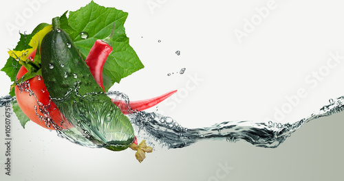 Photos Cucumber, tomato and pepper in a spray of water.
