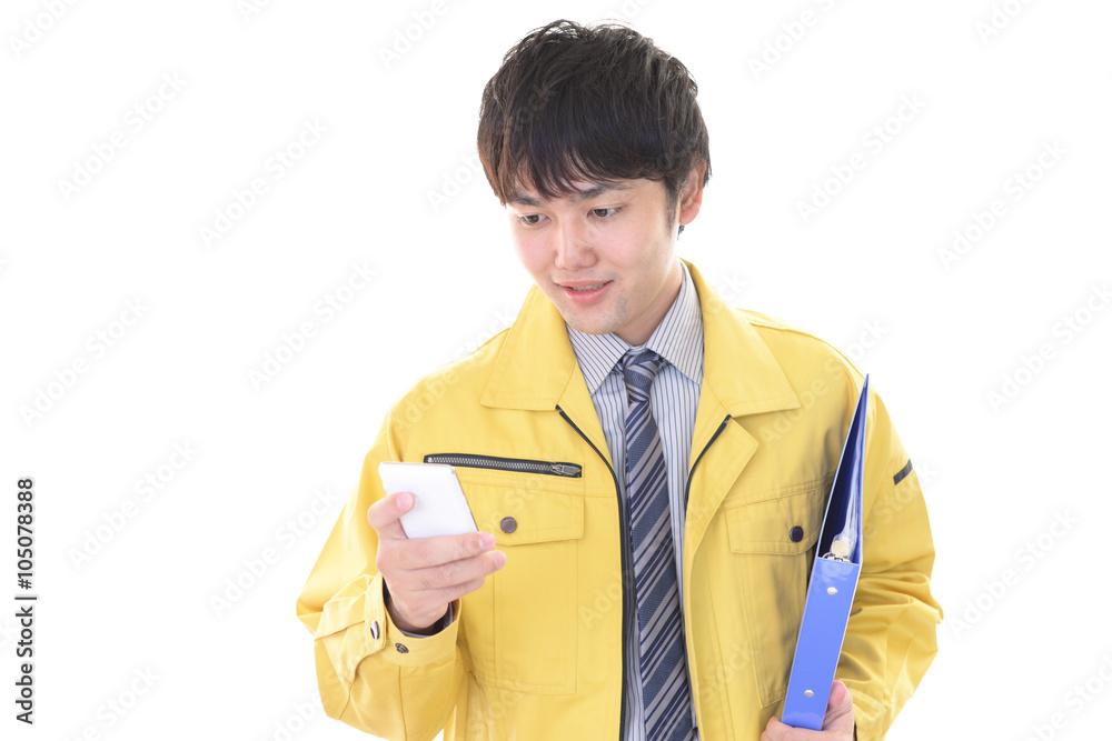 スマートフォンを持つ笑顔の作業員 スマートフォンを持つ笑顔の作業員