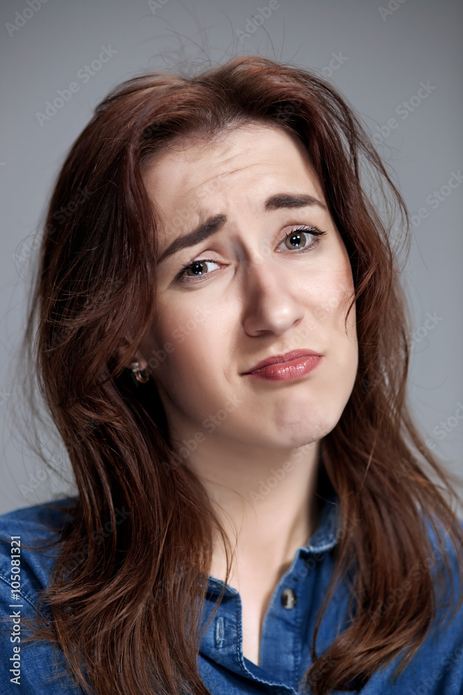 Woman is looking imploring over gray background