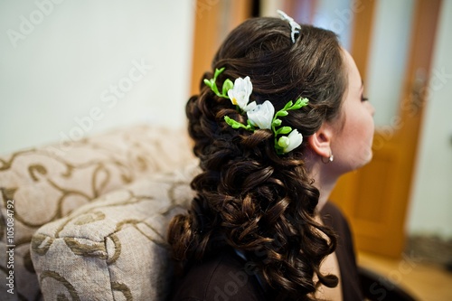 Fresh flowers in curly hair bride