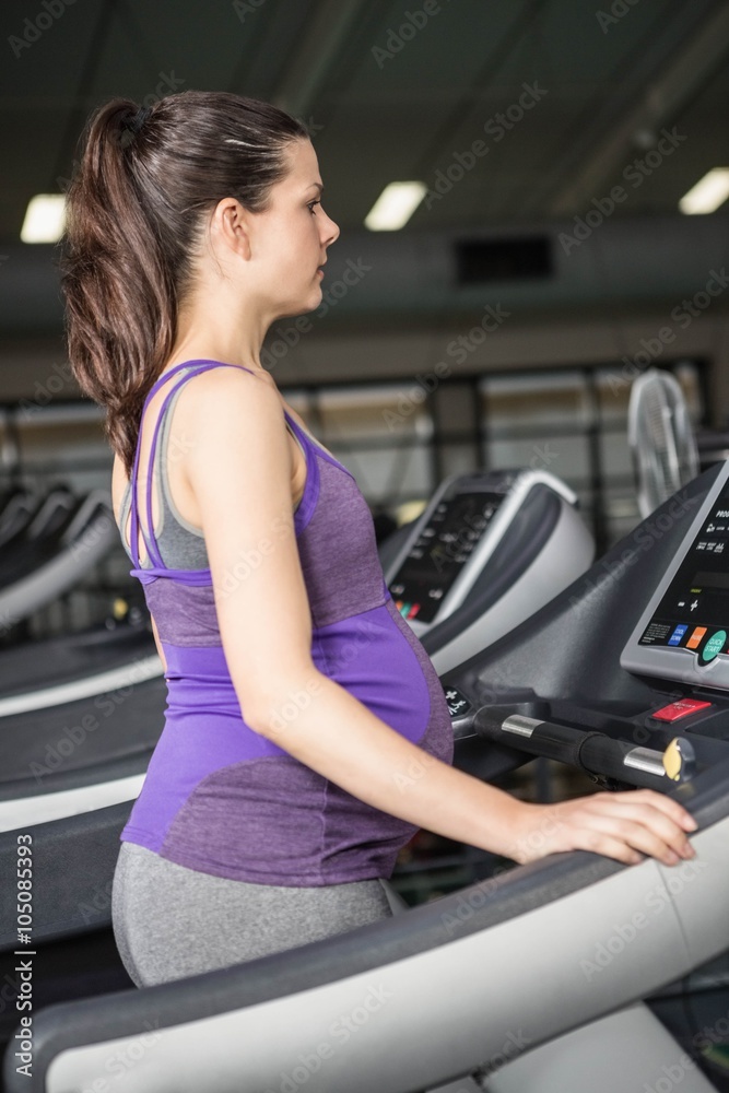 Pregnant woman exercising on a treadmill Pregnant woman exercising on a treadmill