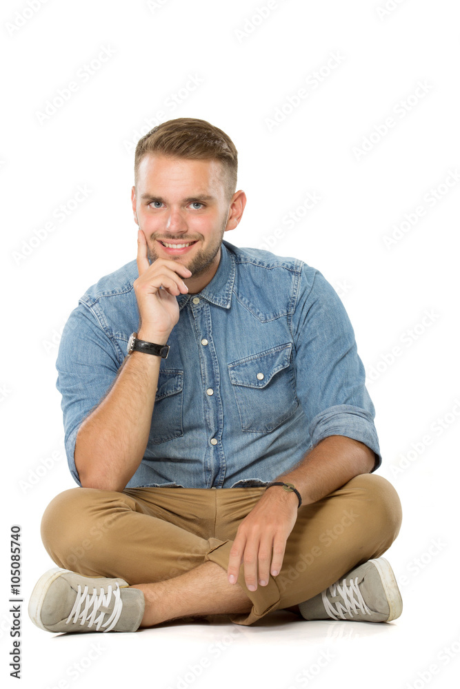 smiling guy sitting on the floor, isolated over white smiling guy sitting on the floor, isolated over white