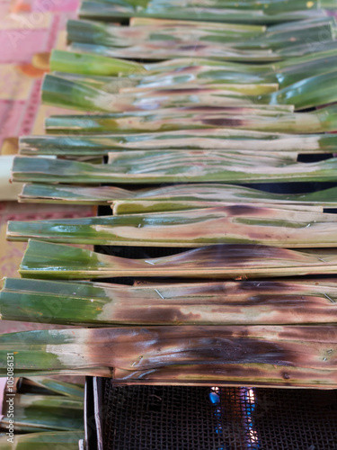 Kanom Jaak, Thai sweetmeat made of flour, coconut and sugar with nipa plam leaves photo