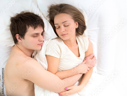Romantic young couple sleeping in bed 