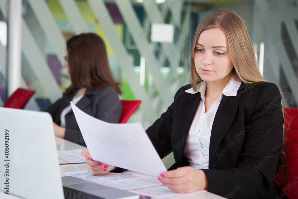 Young pretty business woman with notebook in the office
