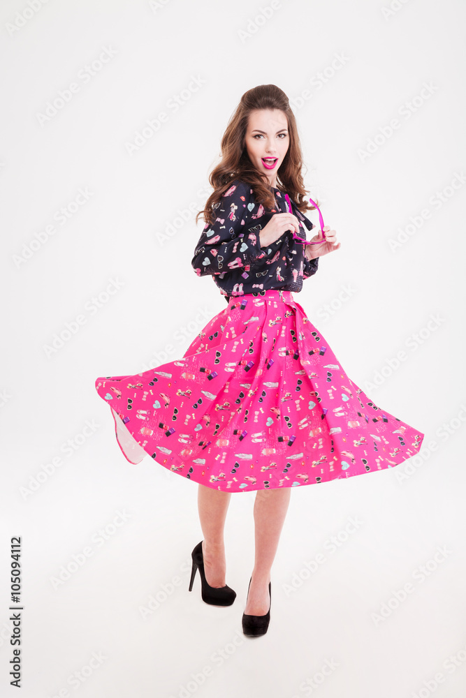Smiling beautiful young woman holding pink sunglasses and whirling around Smiling beautiful young woman holding pink sunglasses and whirling around
