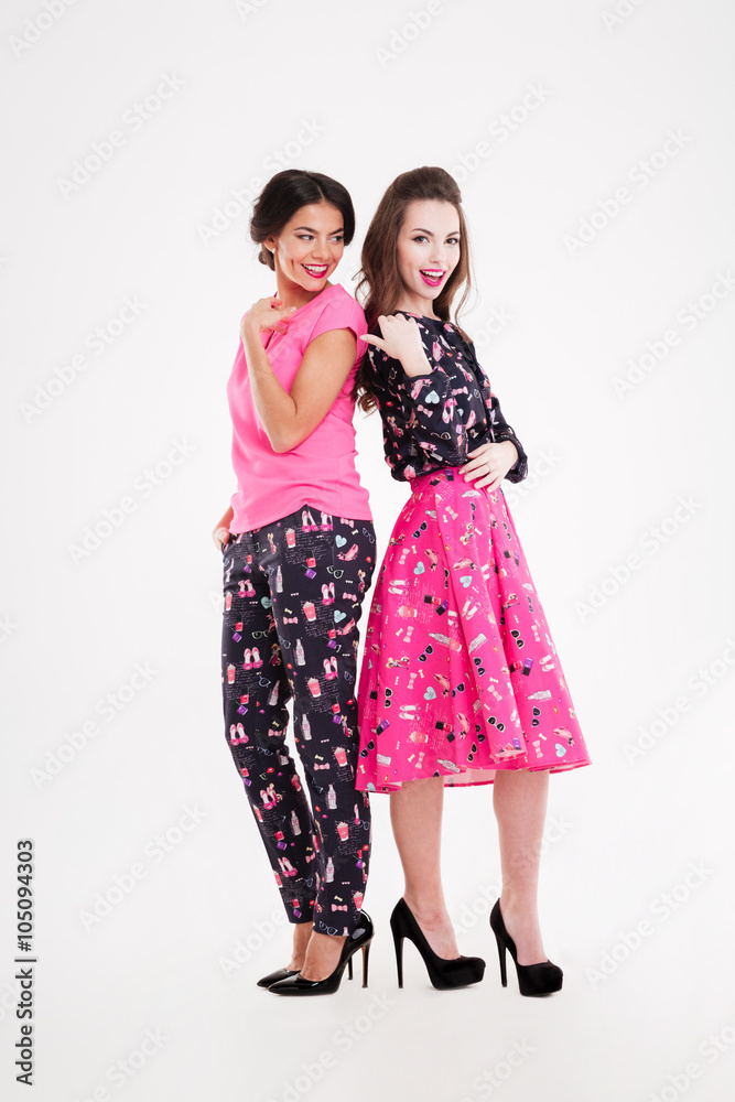 Two cheerful attractive young women standing together