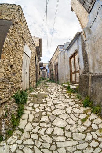 Fisheye view on vanishing medieval narrow pavement street passage with stonemasonry building. Pano Lefkara, Cyprus. 