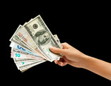 Woman's hand is giving euro and dollars money isolated on black background