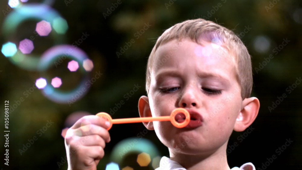 Young boy blowing bubbles, slow motion Young boy blowing bubbles, slow motion