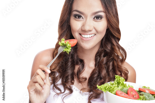 healthy young woman eating vegetables salad