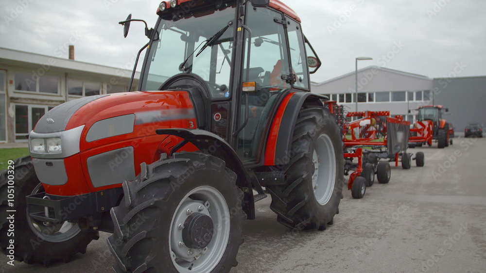 A tractor is parked outside in front of the factory A tractor is parked outside in front of the factory