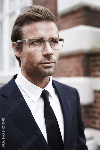 Businessman in suit and spectacles, looking away