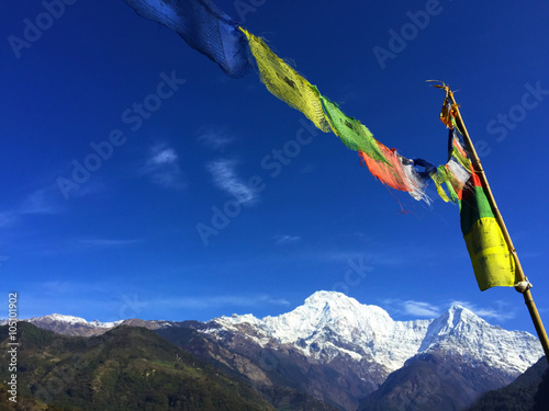 Colorful praying flags and white icy peaks photo