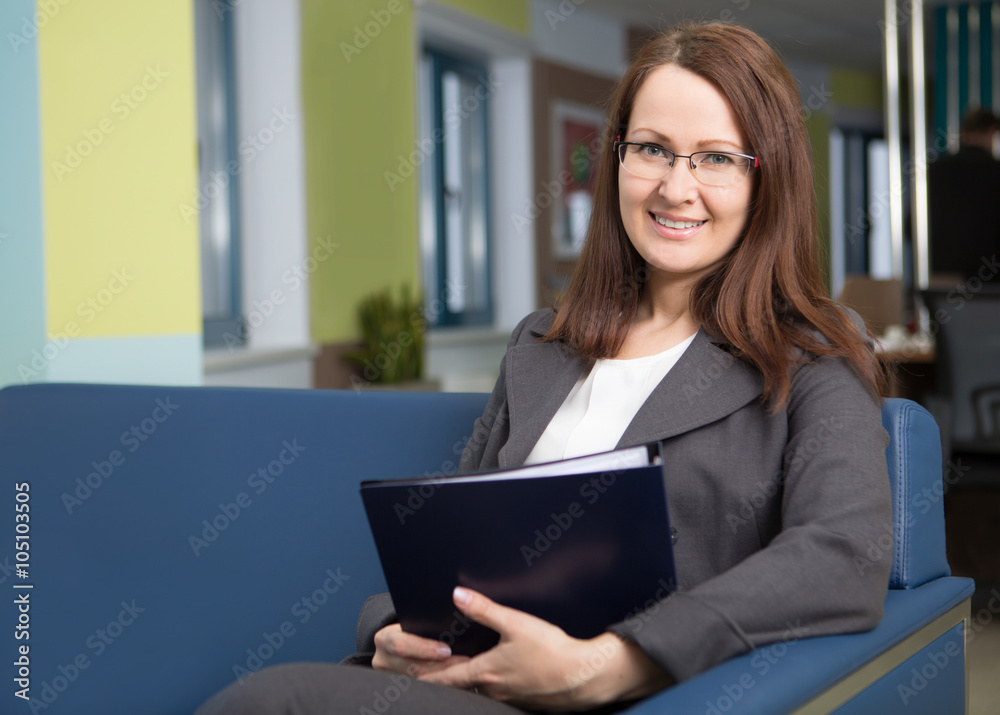 Portrait of successful female sitting in office
Portrait of successful female sitting in office