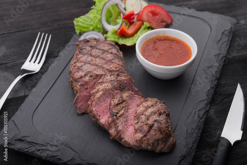 beef steak on with fresh salad on stone