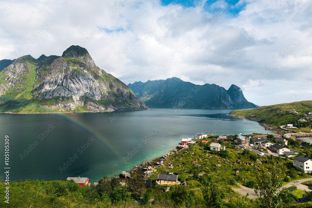 Scenic landscape on Lofoten islands with great mountains near green water. Beautiful rainbow 